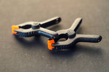 Siyah kelepçe siyah arka plan üzerine turuncu plastik jawson ile çifti