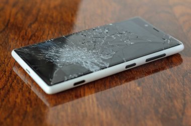 Ahşap masa üzerinde kırık ekran ile Smartphone.