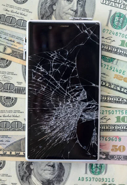 Smartphone with broken display on money background