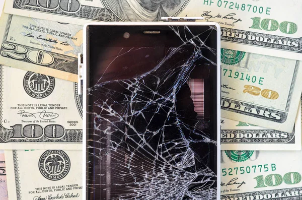 Smartphone with broken display on money background