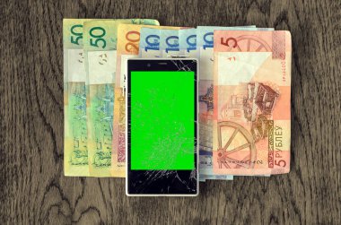 Para Lirası ahşap masa üstünde ile Smartphone.