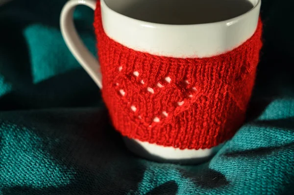 Red Knitted woolen cup with heart pattern — Stock Photo, Image