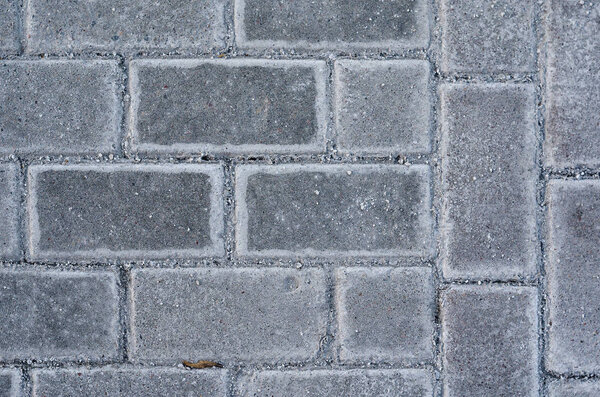 Concrete or cobble gray pavement slabs or stones for floor. Traditional backyard or road paving. Black and white pavement slabs rattern