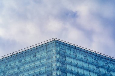 Bulutlu gökyüzü karşı binanın modern parlak cephe