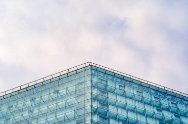 Bulutlu gökyüzü karşı binanın modern parlak cephe