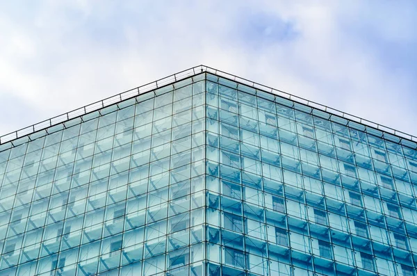 Moderna fachada brillante del edificio contra el cielo nublado — Foto de Stock