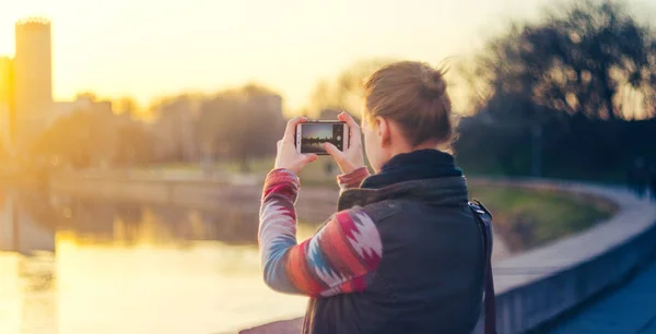 Junge Frau fotografiert die Stadt mit dem Smartphone — Stockfoto