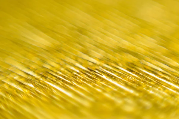 Gold Texture of Embossed Paper. Gold Paper Texture Background. Macro. Shallow depth of field. Abstract background with deep grooves in the texture of corrugated paper