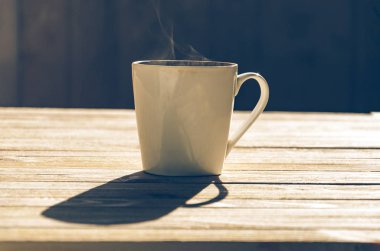 bir fincan sıcak kahve koyu arka plan üzerinde buhar ile. tonlu görüntü.