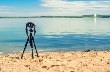 Kumlu sahilde bir tripod üzerinde kamera