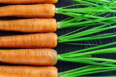 Havuç siyah ahşap arka plan üstünde göster