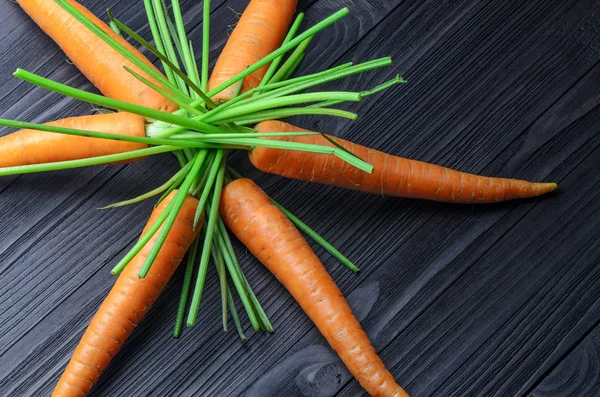 Havuç siyah ahşap arka plan üstünde göster