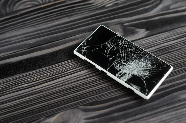 Koyu arkaplanda kırık ekranlı akıllı telefon
