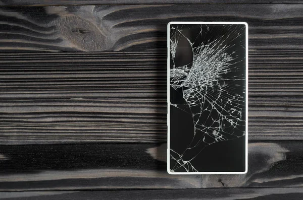 Smartphone med trasig skärm på mörk bakgrund — Stockfoto