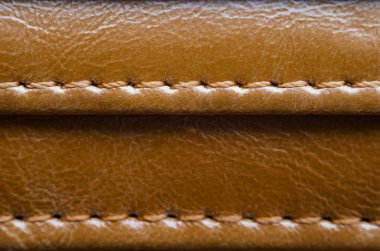 Dikiş ile kahverengi deri dokusuna. Deri giyim yakın çekim unsuru. Dikişleri deri ürünleri