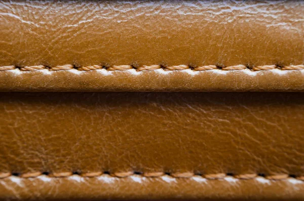 Dikiş ile kahverengi deri dokusuna. Deri giyim yakın çekim unsuru. Dikişleri deri ürünleri