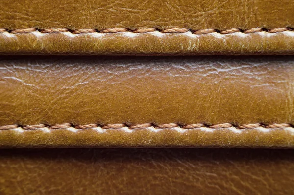 Dikiş ile kahverengi deri dokusuna. Deri giyim yakın çekim unsuru. Dikişleri deri ürünleri