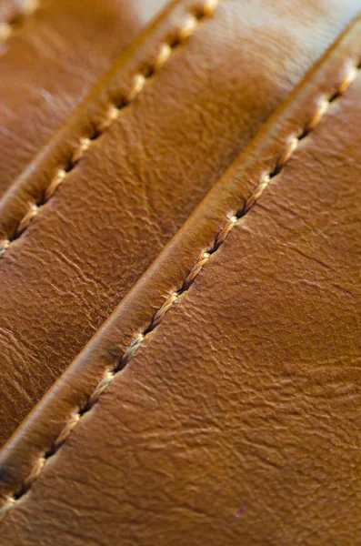Dikiş ile kahverengi deri dokusuna. Deri giyim yakın çekim unsuru. Dikişleri deri ürünleri