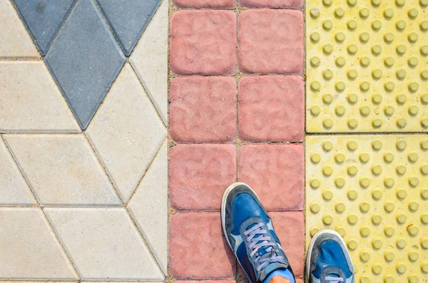 Sundown sarı dokunsal parke döşeme üzerinde spor ayakkabı.