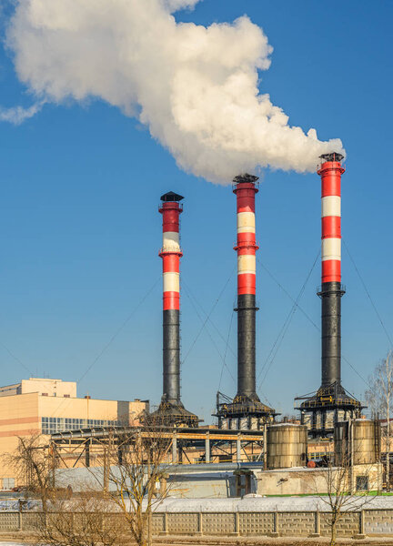 Thermal power plant during winter operation. High chimneys emit a large amount of smoke