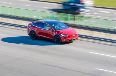 Minsk, Beyaz Rusya - 18 Nisan 2017: Kırmızı Tesla Model X hızlı bir şekilde karayolu boyunca taşır.