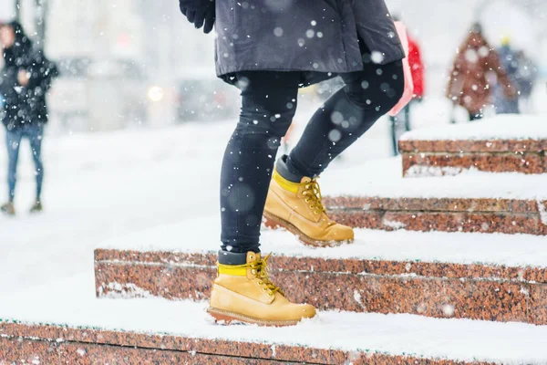 Een vrouw in gele schoenen stijgt op stappen in sity — Stockfoto
