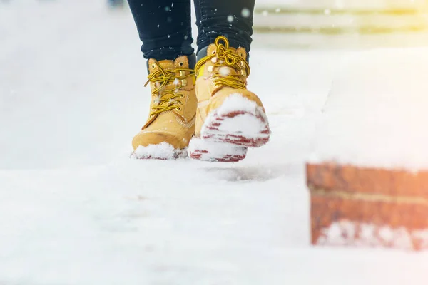 Een vrouw in gele schoenen loopt op een stoep. — Stockfoto