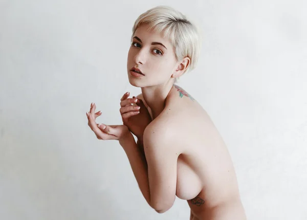 Belle fille blonde près du mur blanc — Photo