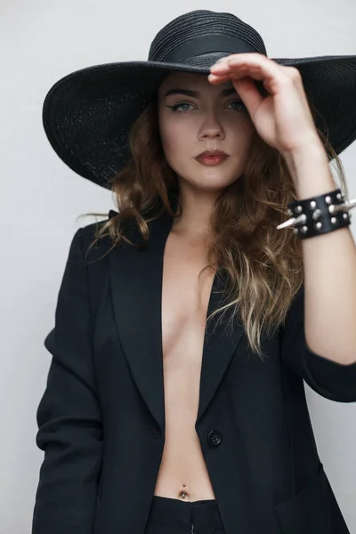 Sexy chica rubia cerca de la pared en un traje negro —  Fotos de Stock