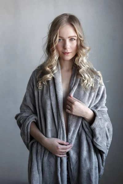 Retrato de mujer sexy joven posando cerca de la pared gris —  Fotos de Stock