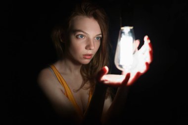 ampul ile kadın fotoğrafı. Portre karanlıkta. Güzel kız.