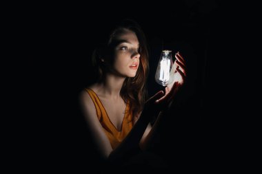 ampul ile kadın fotoğrafı. Portre karanlıkta. Güzel kız.
