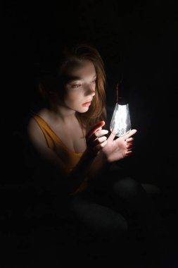 ampul ile kadın fotoğrafı. Portre karanlıkta. Güzel kız.