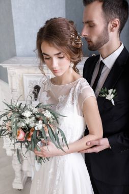 Beyaz bir piyano yakınındaki zarif yeni evliler