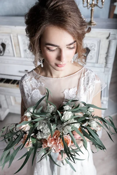 Bella sposa con bouquet vicino al pianoforte bianco — Foto Stock