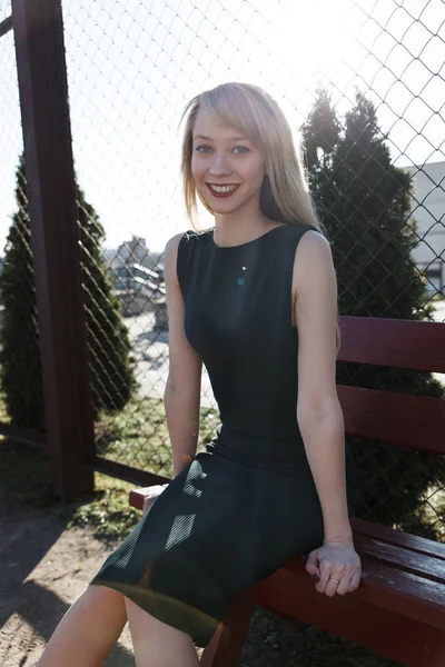 La fille aux cheveux longs sur un banc dans le parc — Photo