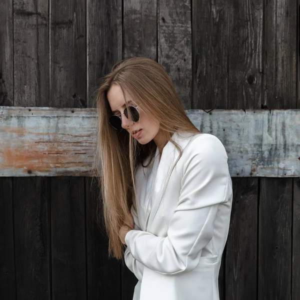 La chica sexy en pantalones blancos sobre pared de madera — Foto de Stock