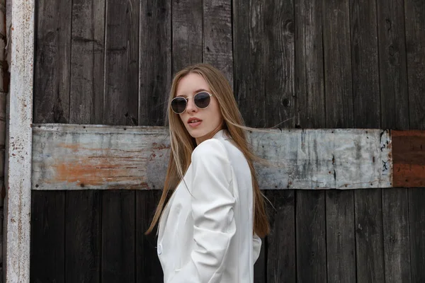 Das sexy Mädchen in weißen Hosen über die Holzwand — Stockfoto