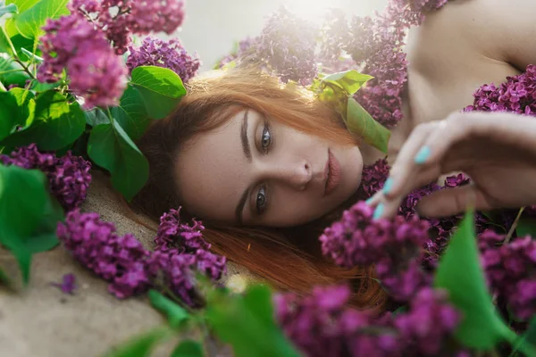 Naakt meisje in paarse bloemen — Stockfoto
