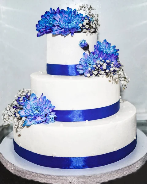 用蓝色彩带和鲜花的婚礼蛋糕 — 图库照片