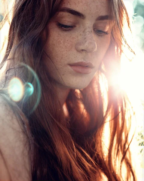 Portret van een meisje met rood haar in de zon — Stockfoto