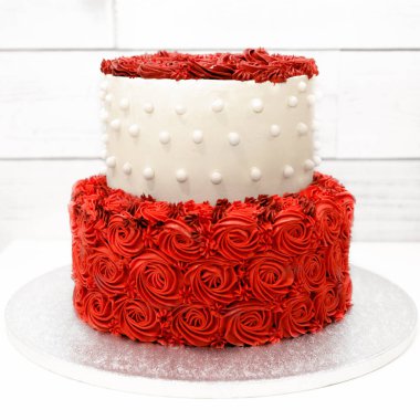 Beyaz arka planda kremadan kırmızı güller olan pasta