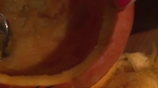 Super close up scooping pumpkin flesh from inside with a spoon — Stock Video