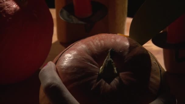 Вырезание верхушки тыквы на Хэллоуин большим ножом, монтаж — стоковое видео