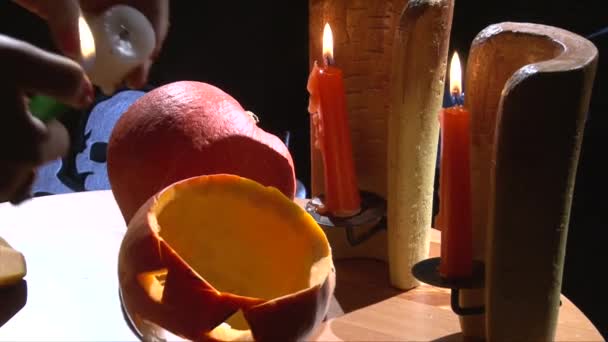 Зробити Хеллоуїн Jack O ліхтар: запалювати свічки і поклав його в гарбуза — стокове відео