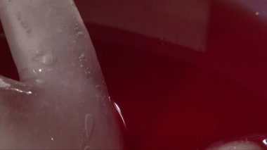 El ile kırmızı içecek scooping, closeup vurdu