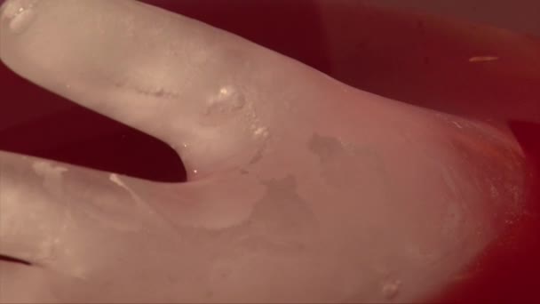 Close-up shot van de hand aanraken van ijs in de vorm van een hand in de punch-drank — Stockvideo