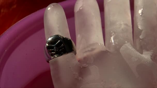 Hielo mano congelada con un anillo de miedo con cráneo, tiro de cerca — Vídeos de Stock