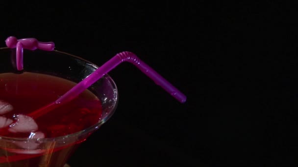 Nehmen Sie ein Glas roten Cocktail auf schwarzem Hintergrund — Stockvideo