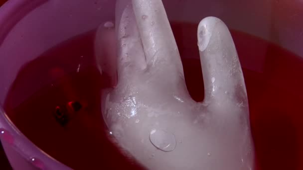 Заморожена рука з страшним кільцем з черепом в контейнері для напоїв — стокове відео